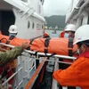 Chuyển thuyền trưởng Lê Ngọc Phúc từ tàu SAR274 lên bờ tại Đà Nẵng. (Ảnh: TTXVN phát)