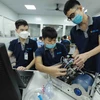 Nhân viên của Công ty Cổ phần Ứng dụng Công nghệ & CNC-Vina lắp ráp thiết bị máy trợ thở tại nhà máy. (Ảnh: Vũ Sinh/TTXVN)