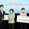 Bà Tô Thị Bích Châu, Chủ tịch Ủy ban MTTQ Việt Nam Thành phố Hồ Chí Minh (giữa) trao thư cảm ơn các doanh nghiệp Hàn Quốc đã ủng hộ công tác phòng, chống dịch COVID-19. (Ảnh: Xuân Khu/TTXVN)