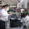 Phó Chủ tịch UBND Thành phố Hồ Chí Minh Dương Anh Đức thăm hỏi công nhân tại các chuyền sản xuất của Công ty Trách nhiệm hữu hạn Pouyuen Việt Nam ở quận Bình Tân. (Ảnh: Thanh Vũ/TTXVN)