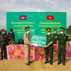 Đại tá Lê Hồng Vương, Chỉ huy trưởng Bộ đội Biên phòng trao Bảng tượng trưng 50 triệu cho Thiếu tướng Chăn Chon, Phó Giám đốc ty Công an tỉnh Srey Veng của Campuchia. (Ảnh: Thanh Tân/TTXVN)