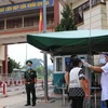 Lực lượng chức năng kiểm tra y tế đối với người vào khu vực cửa khẩu Chi Ma. (Ảnh: Quang Duy/TTXVN)