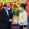 Chủ tịch nước Nguyễn Xuân Phúc tặng chân dung Chủ tịch Hồ Chí Minh cho học sinh xuất sắc trong cuộc thi “Vì một Việt Nam tất thắng.” (Ảnh: Thống Nhất/TTXVN)