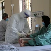 Các bác sỹ đo nồng độ SpO2 cho F0 tại Bệnh viện Dã chiến số 1 ở xã Trưng Vương, thành phố Việt Trì. (Ảnh: Diệp Trương/TTXVN)