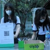 Học sinh Trường THPT Lê Quý Đôn (quận 3) khai báo y tế ở khu vực ngoài cổng trường. (Ảnh: Thu Hoài/TTXVN)