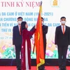 Phó Chủ tịch nước Võ Thị Ánh Xuân gắn Huân chương Lao động hạng Ba lên lá cờ truyền thống của Hội Nạn nhân chất độc da cam/dioxin Việt Nam. (Ảnh: Tuấn Đức/TTXVN)