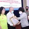 Bà Tô Thị Bích Châu, Chủ tịch Ủy ban MTTQ Việt Nam Thành phố Hồ Chí Minh trao Giấy Biểu dương và biểu trưng tri ân các tổ chức thiện nguyện. (Ảnh: Xuân Khu/TTXVN)