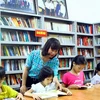 Các em học sinh chăm chú đọc sách tại thư viện. (Ảnh: Tá Chuyên/TTXVN)