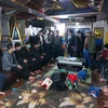 21 đối tượng đánh bạc dưới hình thức xóc đĩa tại tầng hầm quán hát Karaoke Hoàng Dung 86 thuộc xóm Suối Sếu A, xã Nhuận Trạch, huyện Lương Sơn bị Công an bắt giữ. (Ảnh Vũ Hà/TTXVN)