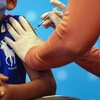 Tiêm vaccine ngừa COVID-19 cho trẻ em tại bệnh viện. (Ảnh: AFP/TTXVN)