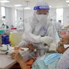 Điều dưỡng viên tận tình chăm sóc bệnh nhân COVID-19 nặng được điều trị tích cực tại Bệnh viện hồi sức COVID-19 Thành phố Hồ Chí Minh. (Ảnh: Thanh Vũ/TTXVN)