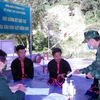 Các chiến sỹ Trạm kiểm soát, Đồn Biên phòng Pa Ủ ở huyện Mường Tè, tỉnh Lai Châu tuyên truyền, phát khẩu trang phòng, chống dịch COVID-19 cho người dân. (Ảnh: Việt Hoàng/TTXVN)