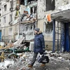 Người dân rời khỏi một tòa nhà đổ nát sau vụ pháo kích tại thành phố Kharkiv, Ukraine, ngày 8/3/2022. (Ảnh: AFP/TTXVN)