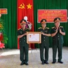 Thiếu tướng Hồ Minh Phương, Phó Chủ nhiệm Chính trị Quân khu 9 trao Huân chương Chiến công hạng Ba cho Tập thể Đội K93. (Ảnh: Thanh Sang/TTXVN)