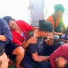 Công nhân nhập cư ngồi trên thuyền trong chiến dịch cứu hộ ở vùng biển ngoài khơi Indonesia. (Nguồn: AFP)