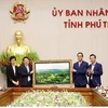 Lãnh đạo Ủy ban MTTQ Việt Nam tỉnh Phú Thọ tặng ảnh lưu niệm “Đồi chè Long Cốc” cho đại diện lãnh đạo Ủy ban Nhà nước về người Việt Nam ở nước ngoài. (Ảnh: Trung Kiên/TTXVN)