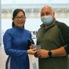 Nhân viên VNPT Đà Nẵng tặng và hướng dẫn du khách quốc tế sử dụng sim điện thoại miễn phí được tặng khi vừa đến Sân bay quốc tế Đà Nẵng. (Ảnh: Trần Lê Lâm/TTXVN)