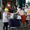 Tặng quà cho các hành khách Hàn Quốc đến sân bay quốc tế Đà Nẵng. (Ảnh: Trần Lê Lâm/TTXVN)