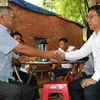 Chủ tịch UBND huyện Long Thành Lê Văn Tiếp (phải) và người dân bắt tay đã tìm được tiếng nói chung về giải phóng mặt bằng. (Ảnh: Công Phong/TTXVN)