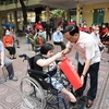 Hội Chữ thập Đỏ Việt Nam tặng quà cho người khuyết tật, người có hoàn cảnh khó khăn do dịch trên địa bàn quận Hoàn Kiếm. (Ảnh: Thanh Tùng/TTXVN)