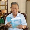 Ông Phạm Thanh Phong xem lại cuốn hồi ký khi vào Chiến khu Cách mạng. (Ảnh: Thanh Bình/TTXVN)