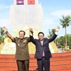 Thủ tướng Phạm Minh Chính và Thủ tướng Campuchia Hun Sen thể hiện tình đoàn kết tại Khu vực X16, điểm dừng chân trong hành trình cứu nước của Thủ tướng Hun Sen ở xã Lộc Tấn, huyện Lộc Ninh, tỉnh Bình Phước, sáng 20/6/2022. (Ảnh: Dương Giang/TTXVN)