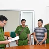 Đại diện Cơ quan Cảnh sát điều tra Công an tỉnh thi hành lệnh bắt tạm giam Nguyễn Văn Cuộc. (Ảnh: TTXVN phát)