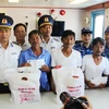 Đại diện Hải đoàn 32, Bộ Tư lệnh Vùng cảnh sát biển 3 trao quà hỗ trợ cho 4 ngư dân gặp nạn may mắn sống sót sau gần 10 ngày lênh đênh trên biển. (Ảnh: Phan Sáu/TTXVN)