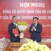Chủ tịch Quốc hội Vương Đình Huệ trao Quyết định của Bộ Chính trị và tặng hoa ông Ngô Văn Tuấn. (Ảnh: Doãn Tấn/TTXVN)