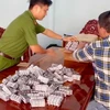 Lực lượng chức năng kiểm đếm số tang vật vừa thu giữ. (Ảnh: TTXVN phát)