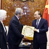 Chủ tịch nước Nguyễn Xuân Phúc trao quà lưu niệm tặng nguyên Thủ tướng Israel Ehud Barak. (Ảnh: Thống Nhất/TTXVN)