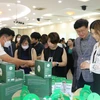 Các doanh nhân Hàn Quốc xem sản phẩm đặc sản của tỉnh Long An. (Ảnh: Thanh Bình/TTXVN)
