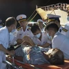 Lực lượng Hải quân đưa ngư dân bị bệnh lên bờ bàn giao cho người nhà và địa phương để đưa đi cấp cứu ở bến cảng ở tỉnh Khánh Hòa. (Ảnh: TTXVN phát)