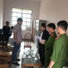 Ông Nông Văn Hoành (bìa trái) nghe đọc quyết định tạm giữ hình sự, điều tra về hành vi Lạm dụng chức vụ quyền hạn chiếm đoạt tài sản. (Ảnh: TTXVN phát)