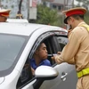 Cảnh sát giao thông kiểm tra nồng độ cồn của lái xe. (Ảnh: Nam Sương/TTXVN)
