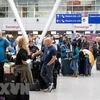 Hành khách chờ đợi tại sân bay. (Ảnh: AFP/TTXVN)