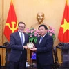 Giám đốc Học viện Chính trị quốc gia Hồ Chí Minh Nguyễn Xuân Thắng tặng quà lưu niệm cho Đại sứ Australia tại Việt Nam Andrew Goledzinowski. (Ảnh: Văn Điệp/TTXVN)