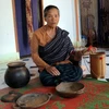Nữ Nghệ nhân dân gian Ma Ly giới thiệu các sản phẩm gốm đã làm của bà. (Ảnh: Chu Quốc Hùng/TTXVN)