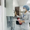 Nhân viên y tế thao tác để chuyển mẫu xét nghiệm bằng hệ thống vận chuyển mẫu khí nén tại Bệnh viện đa khoa Thống Nhất. (Ảnh: Lê Xuân/TTXVN)