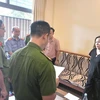 Cơ quan Công an đọc lệnh bắt bị can để tạm giam và lệnh khám xét chỗ đối với đối tượng Nguyễn Thị Nhung. (Ảnh: TTXVN phát)
