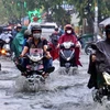 Người dân vượt dòng nước ngập trên đường Tô Ngọc Vân, thành phố Thủ Đức, Thành phố Hồ Chí Minh. (Ảnh: Hồng Giang/TTXVN)