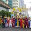 Phụ nữ tỉnh Khánh Hòa diễu hành trên phố với trang phục áo dài truyền thống và nón lá. (Ảnh: Phan Sáu /TTXVN) 