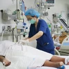 Nhân viên y tế của Khoa Cấp cứu-Hồi sức tích cực-Chống độc người lớn, Bệnh viện Bệnh Nhiệt đới Thành phố Hồ Chí Minh chăm sóc cho bệnh nhân sốt xuất huyết nặng. (Ảnh: Đinh Hằng/TTXVN)