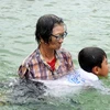 Bà Trần Thị Kim Thia dạy cho trẻ động tác bơi. (Ảnh: Nhựt An/TTXVN)