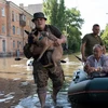 Quân đội hỗ trợ người dân sơ tán khỏi khu vực ngập lụt sau vụ vỡ đập thủy điện Kakhovka tại tỉnh Kherson, miền Nam Ukraine, ngày 7/6. (Ảnh: AFP/TTXVN)