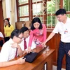 Bà Đặng Thúy Vân, Chủ tịch UBND phường Việt Hưng (áo đỏ) hướng dẫn các Bí thư chi bộ sử dụng phần mềm. (Ảnh: TTXVN)