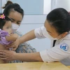 Bác sỹ Bệnh viện Nhi đồng 1 Thành phố Hồ Chí Minh kiểm tra cho bệnh nhi trước khi xuất viện. (Ảnh: Đinh Hằng/TTXVN)