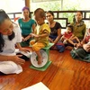Nhân viên y tế kiểm tra sức khỏe và tư vấn dinh dưỡng trẻ em cho đồng bào dân tộc. (Ảnh: Dương Ngọc/TTXVN)