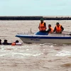 Lực lượng Bộ đội Biên phòng Cà Mau tiếp cận, cứu vớt 3 người trôi dạt trên biển đưa vào bờ an toàn. (Ảnh: TTXVN phát)