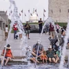 Người dân tránh nóng bên đài phun nước tại Washington, D.C., Mỹ, ngày 11/7 vừa qua. (Ảnh: THX/TTXVN)
